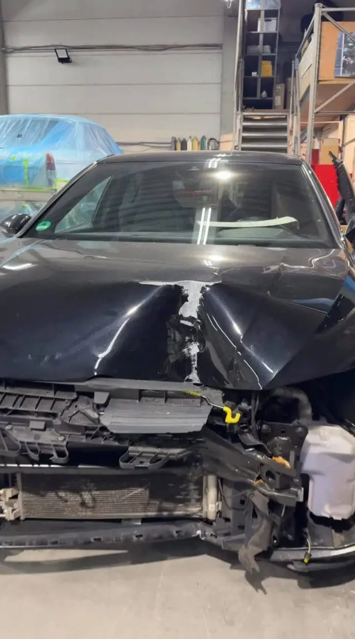 Unfallwagen mit eingedrückter Front in der Werkstatt